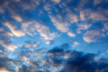 Dramatic blue sky with dark clouds at sunset to illustrate bad weather, anxiety, worry and despondency.