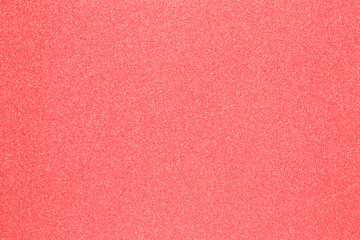 Red glitter texture. Close-up of a light red background with red color sparkle. Macro.