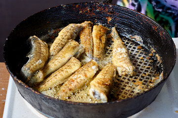 Frying Gobius sobitis (goby fish) in a pan. Cooking fried fish in a pan. Mediterranean cuisine, junk food, tasty snacks for beer concept