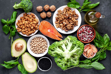 Omega 3 food sources on stone background. Foods high in fatty acids, including seafood, vegetables, nuts and seeds.