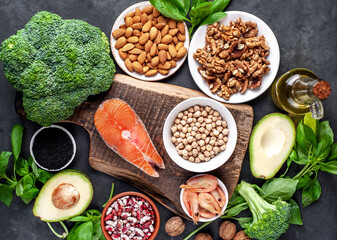 Omega 3 food sources on stone background. Foods high in fatty acids, including seafood, vegetables, nuts and seeds.