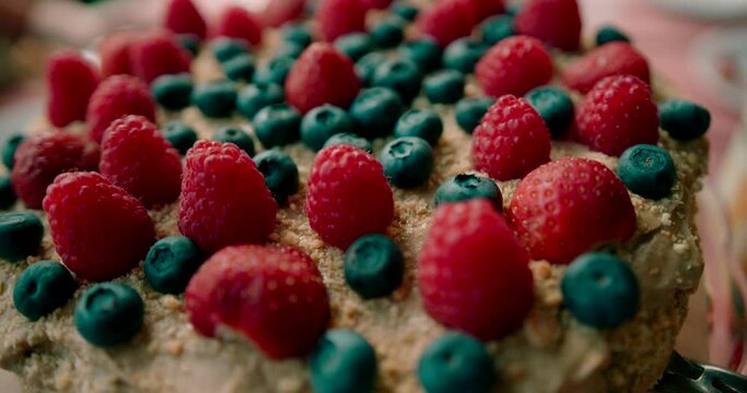 Close up shot of the fresh delicious cake with strawberries and blueberries toppings