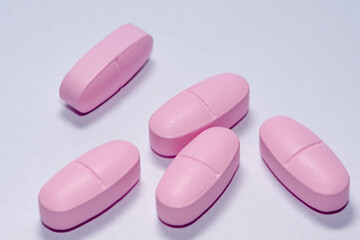 closeup of three pink pills, Pink pill vitamin medicine.