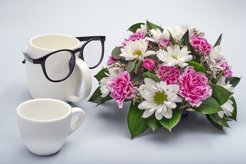 Celebration background for happy father's day. Creative breakfast with funny face made from a cups of coffee and glasses. Flowers for dad.