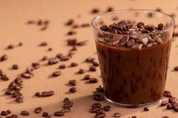 acrylic cup with brigadeiro and chocolate sprinkles on brown background