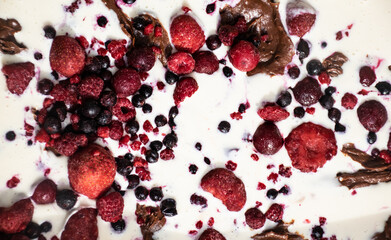 Mix of colorful frozen forest berries on top of the cake.
