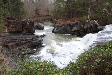 Water rushes by boulders in an Arkansas river in autumn