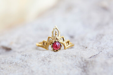 Golden metal silver ornamental ring with garnet mineral stone