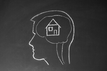 Concept man thinking about buying a home. Male head and house on a chalk board.