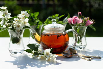 Flowers of rose, jasmine and mint leaves are in a Turkish glass mugs. Ingredients for Herbal Tea.