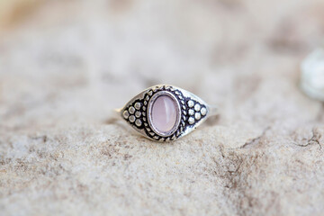 White metal silver ornamental ring with red rose quartz mineral stone