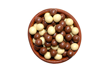 Chocolate hazelnuts covered wit milk chocolate and white chocolate in a brown bowl isolated on white background. Choco hazelnuts dragee 