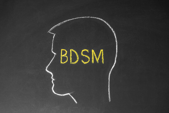 Concept man thinks about BDSM. Male head and the inscription BDSM on the chalk board.