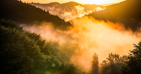 epic summer panorama of foggy sunset in mountains