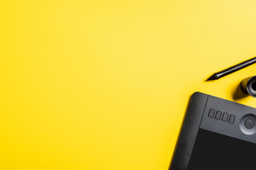 top view of stylus near drawing tablet on yellow