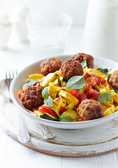 Pappardelle Pasta with Meatballs and fresh Basil on bright background. Close up. 
