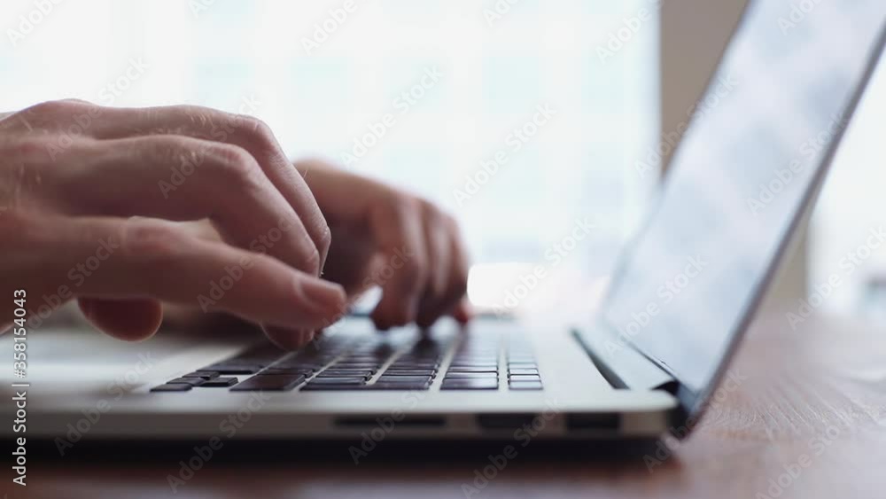 Wall mural close-up of hands of unrecognizable businessman typing on laptop computer at the desk in modern room