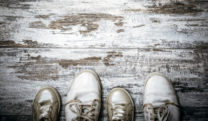 Father and daughter white shoes on shabby chic wooden background. Fathers day concept.