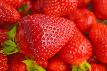 Strawberry closeup. Macro image of fresh strawberries on dark background
