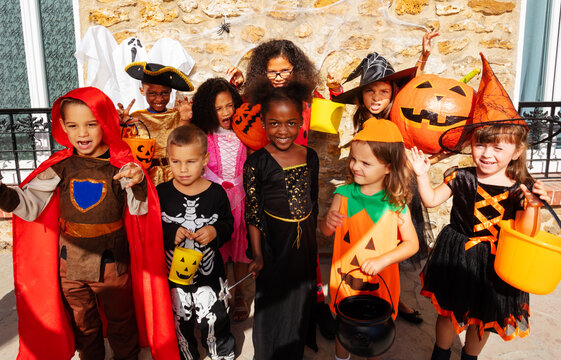 Large Group Of Kids In Halloween Costumes Stand Together Smiling Showing Spooky Gestures Looking On Camera