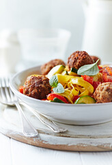 Pappardelle Pasta with Meatballs and fresh Basil on bright background. Close up.