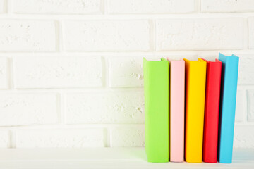 Obraz na płótnie Canvas Multi coloured school books on a white background with copy space.