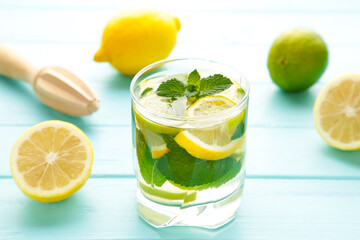 Water detox with lemon, lime and mint on a blue background.