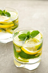 Water detox with lemon, lime and mint on a grey concrete background