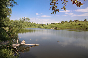 Beautiful river in the highlands in summer. Lake in an ecologically clean park reserve on a background of hills. A pretty landscape in the spring. Stock photo for design