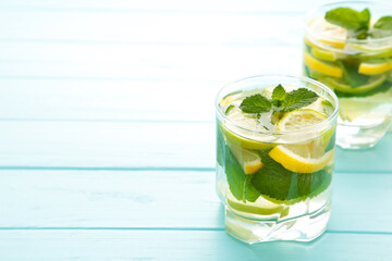 Water detox with lemon, lime and mint on a blue background. Detox drink with copy space