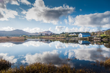 Fototapeta premium Reflection of a house in a lake on sunny day in Ireland