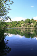 Beautiful river in the highlands in summer. Lake in an ecologically clean park reserve on a background of hills. A pretty landscape in the spring. Stock photo for design