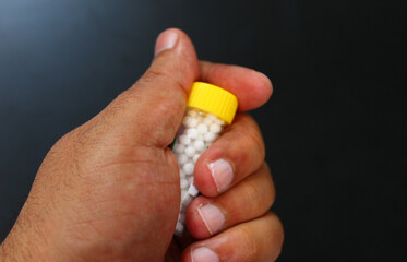 hand holding homeopathic pills