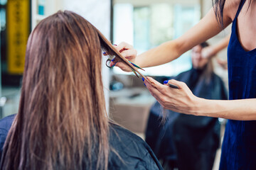 Close-up of a woman in hair salon getting her hair cut by the hairdresser.