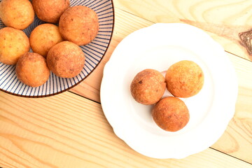 Fresh aromatic, cheese donuts, close-up, on a ceramic plate, on a wooden table.