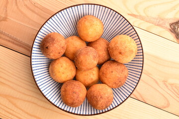 Fresh aromatic, cheese donuts, close-up, on a ceramic plate, on a wooden table.