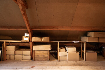 Obraz na płótnie Canvas Old wooden attic interior with old cardboard boxes for storage or moving,