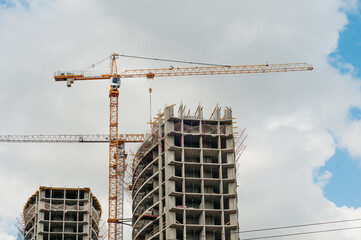 Construction site background. Hoisting cranes and new multi-storey buildings. I.ndustrial background.