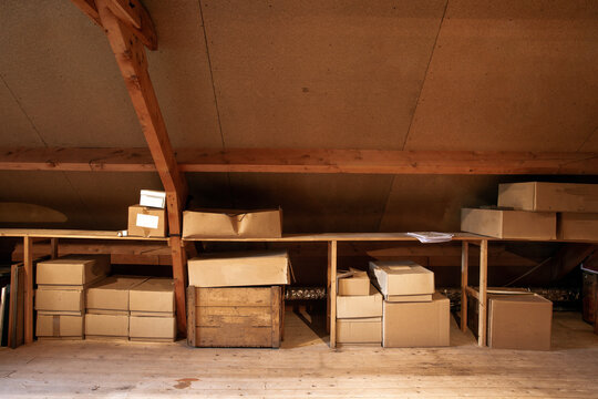 Old Wooden Attic Interior With Old Cardboard Boxes For Storage Or Moving,