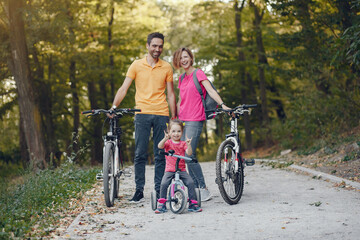 Fototapeta na wymiar Family in a park. People with a bicycle. Parents with little daughter.