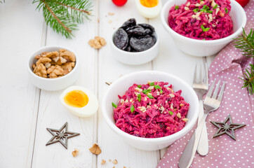 Salad of boiled beet. Beetroot salad with prunes, walnuts, eggs and sour cream in a bowl on white background. Healthy food. Salad for Christmas and New Year. Horizontal orientation. Copy space