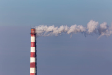 chimney with smoke on the background of the blue sky