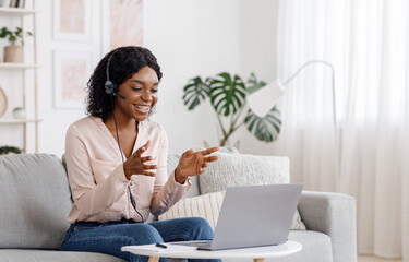 Video Conference. Smiling african woman having web call on laptop at home