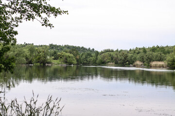 Beautiful river in the highlands in summer. Lake in an ecologically clean park reserve on a background of hills. A pretty landscape in the spring. Stock photo for design