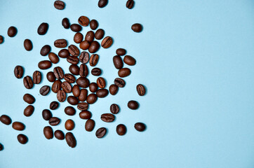 Coffee beans spilling out of a cristal jar on mint blue background. Pastel colored wallpaper, trendy fashion photo