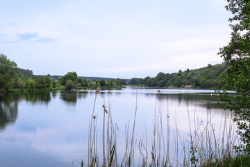 Beautiful river in the highlands in summer. Lake in an ecologically clean park reserve on a background of hills. A pretty landscape in the spring. Stock photo for design