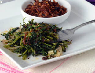 Close up.  Leafy green water spinach stir fries. with  Appetizing Spicy Maldives fish dish  - (dried fish) - fine dining restaurant