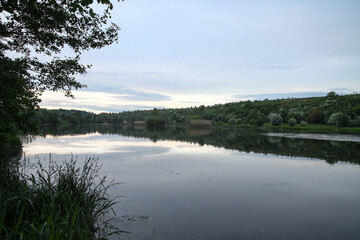 Beautiful river in the highlands in summer. Lake in an ecologically clean park reserve on a background of hills. A pretty landscape in the spring. Stock photo for design