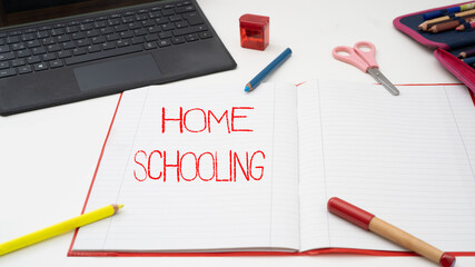 Homeschooling background - laptop, empty exercise book, scissors, sharpener, fountain pen, pencil...