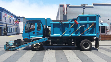 Blue Street Sweeper Truck in Zebra Crossing in Peaceful Oceanside Shopping Center